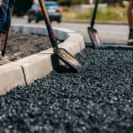 Road,Workers,With,Shovels,In,Their,Hands,Throw,Forked,Asphalt