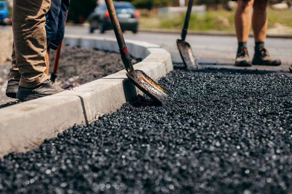 Road,Workers,With,Shovels,In,Their,Hands,Throw,Forked,Asphalt