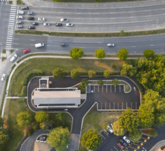 Aerial drone view of a completed asphalt parking lot paving project in daylight